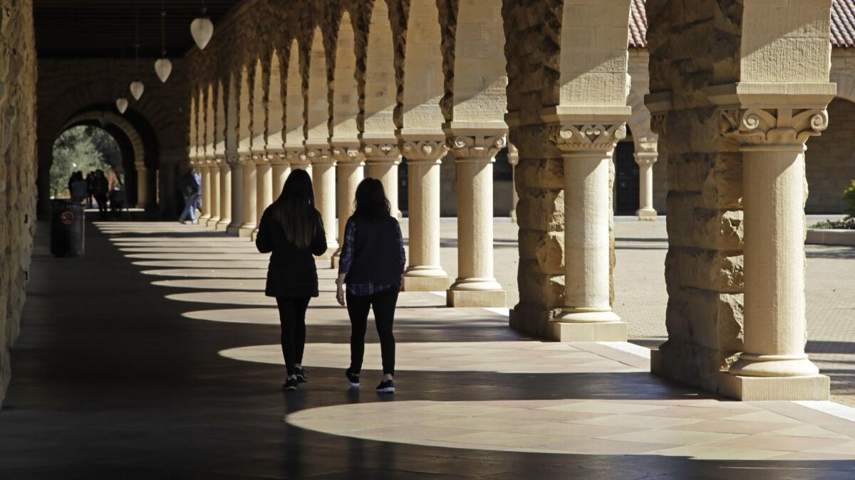 Students walk on the Stanford University campus in Santa Clara, Calif.