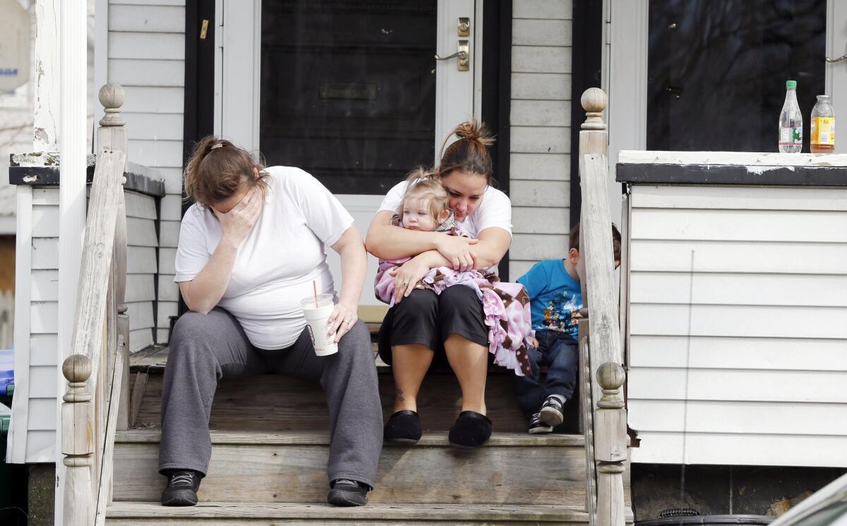 Grieving neighbors sit outside the house of Krystle Campbell's parents in Medford, Mass., on Tuesday. Campbell was killed in Monday's explosions at the finish line of the Boston Marathon.
