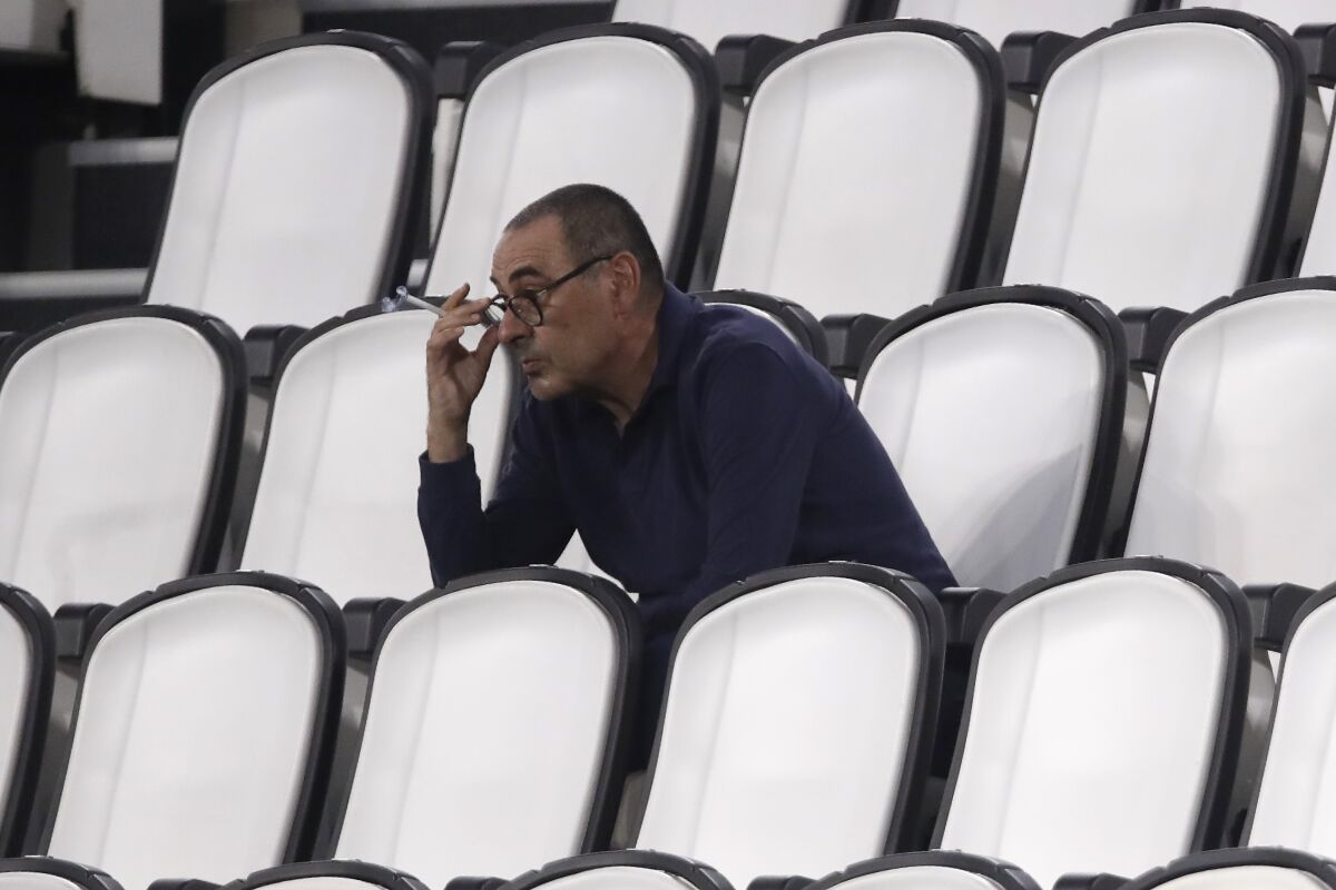 FILE - In this Saturday, Aug. 1, 2020 filer, Juventus' head coach Maurizio Sarri smokes during a Serie A soccer match between Juventus and Roma, at the Allianz stadium in Turin, Italy. Cristiano Ronaldo scored twice but could not prevent Juventus from going out of the Champions League despite a 2-1 victory over Lyon in its rearranged second-leg match Friday. The French team progressed to the quarterfinals on away goals after a 2-2 draw on aggregate. (AP Photo/Luca Bruno, File)