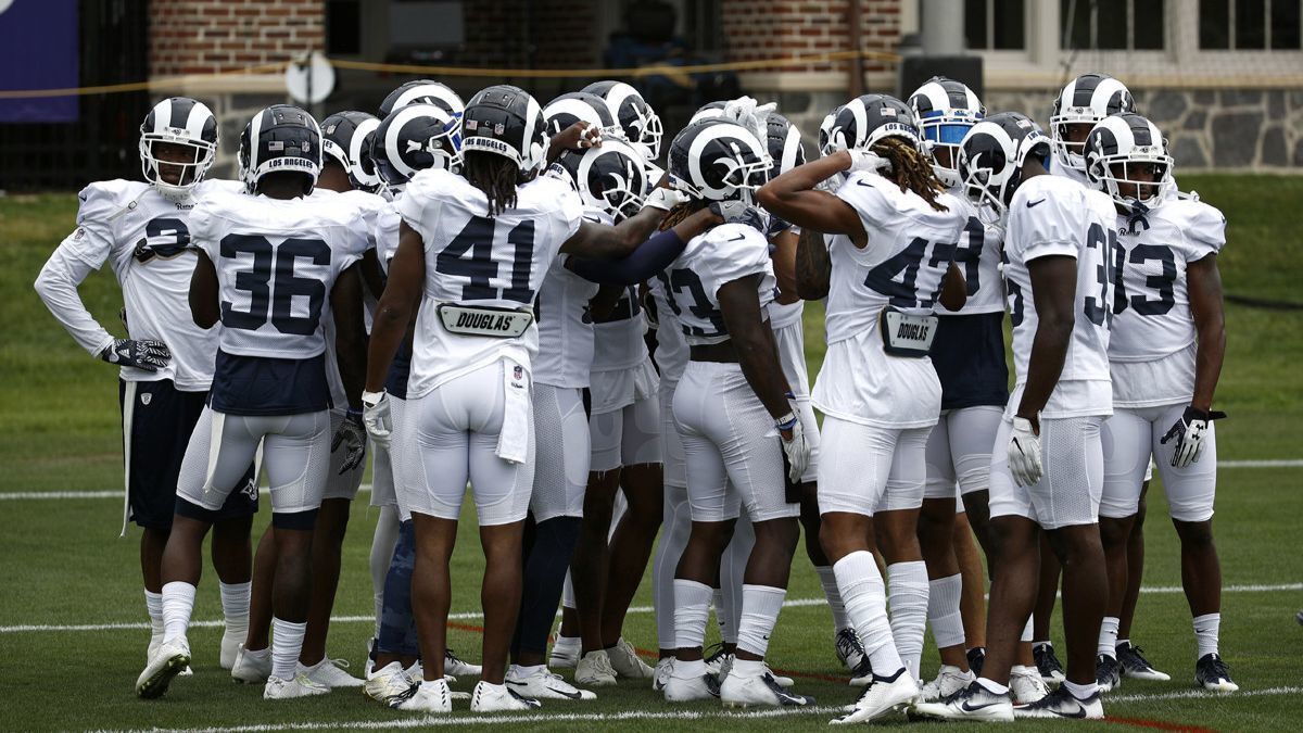 Rams players huddle during a joint training camp practice at the Baltimore Raven's headquarters on Tuesday in Owings Mills, Md.
