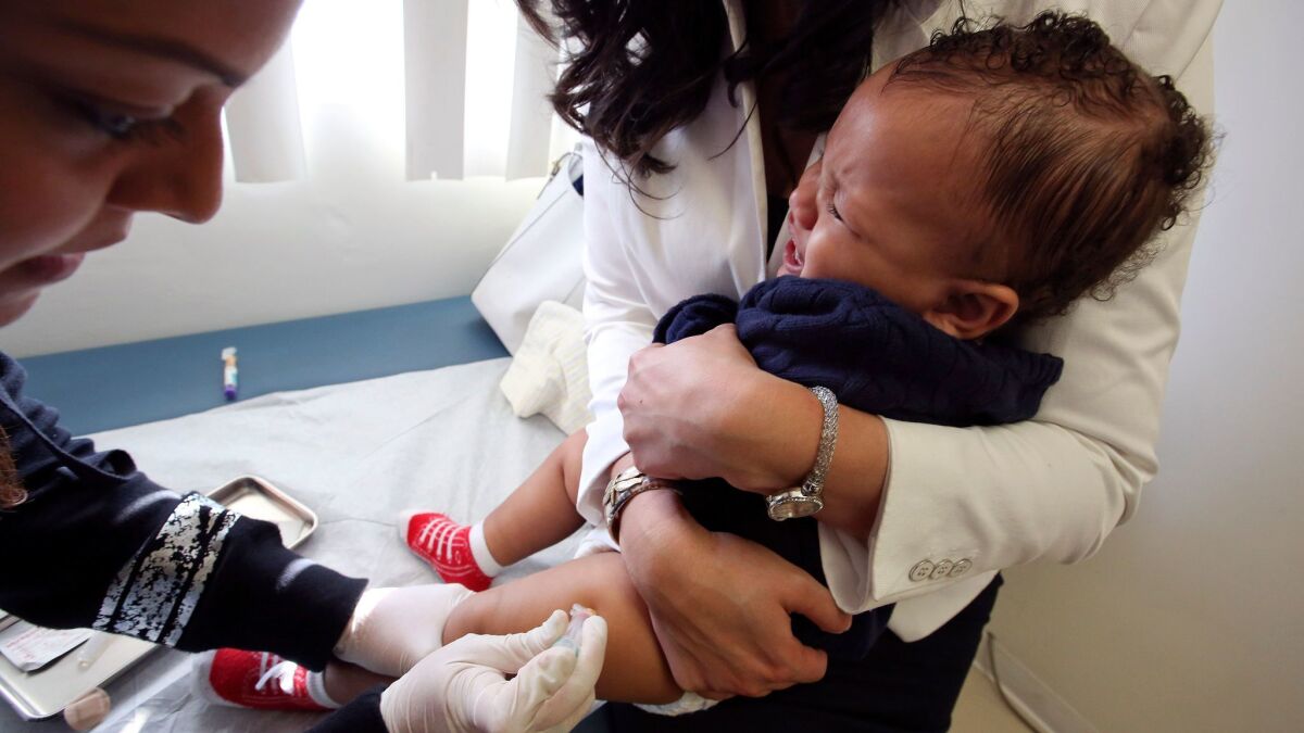 Medical assistant Daisi Minor gives an MMR vaccine, which protects against measles, mumps and rubella, to 1-year-old Kristian Richard at the Medical Arts Pediatric Med Group on Wilshire Boulevard in Los Angeles.