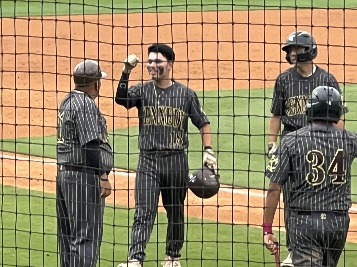 Kennedy's Abel Castillo is all smiles after an RBI double in the seventh while greeting coach Andy Rodriguez. 