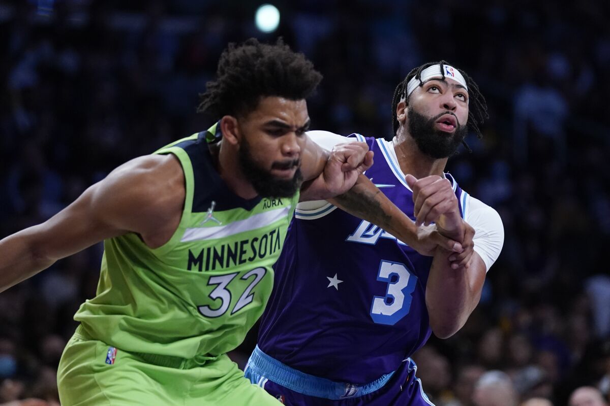 Lakers forward Anthony Davis and Minnesota Timberwolves center Karl-Anthony Towns fight for rebounding position.