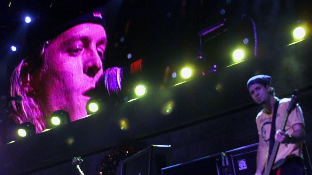 Puddle of Mudd singer Wesley Reid Scantlin, left, shown on a video screen behind bassist Douglas John Ardito during a performance, was arrested in 2017 for trying to bring a firearm onto a plane at LAX.