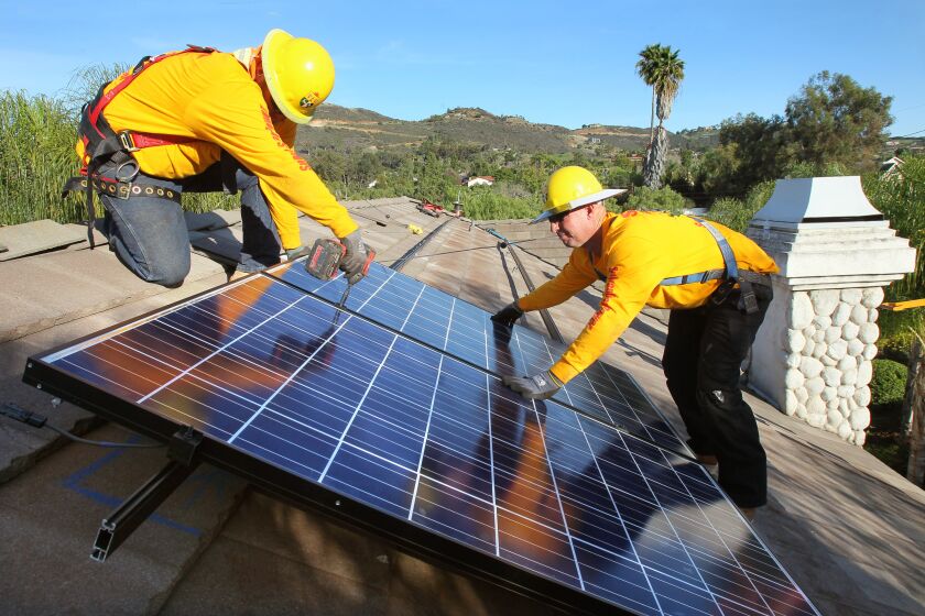 February 2, 2015_Vista, California_USA_| Workers from Sullivan Solar Power, of San Diego, install solar panels on the roof of a large, upscale home in Vista. At left is Cory Hurley and at right is Eric Hartley. |_Mandatory Photo Credit: Photo by Charlie Neuman/UT San Diego/Copyright 2014 San Diego Union-Tribune, LLC
