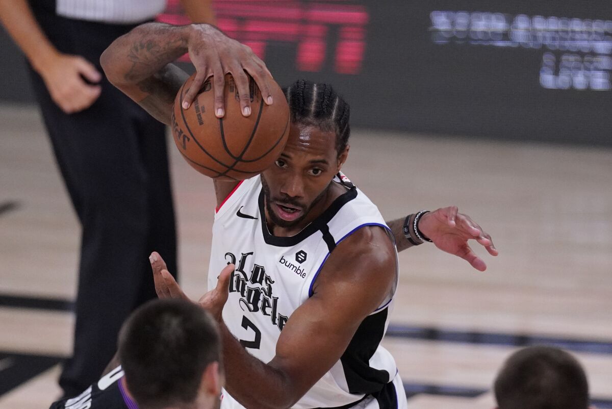 Los Angeles Clippers' Kawhi Leonard (2) grabs a loose ball during the first half of an NBA conference semifinal playoff basketball game against the Denver Nuggets, Wednesday, Sept. 9, 2020, in Lake Buena Vista, Fla. (AP Photo/Mark J. Terrill)