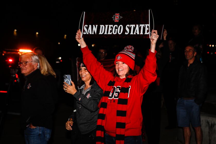 San Diego State fans cheer as the Aztecs' mens basketball team's bus arrives outside the Fowler Athletic Center on Saturday.