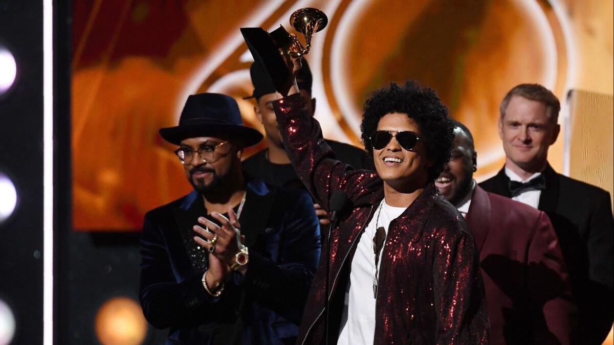 Bruno Mars hoists his Grammy for album of the year Sunday in New York.