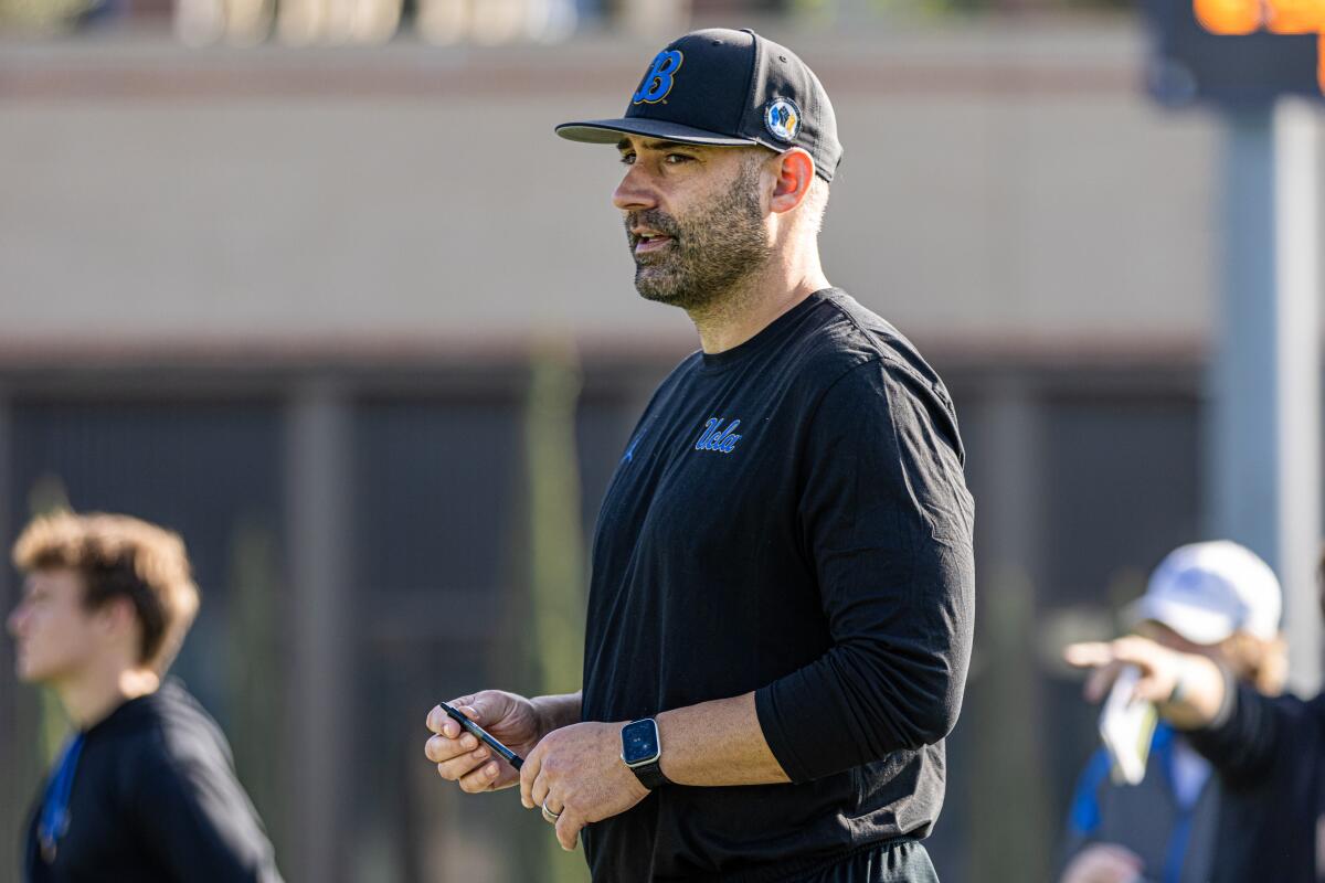 Bryce McDonald, the UCLA football team chief of staff, stands on the practice field.