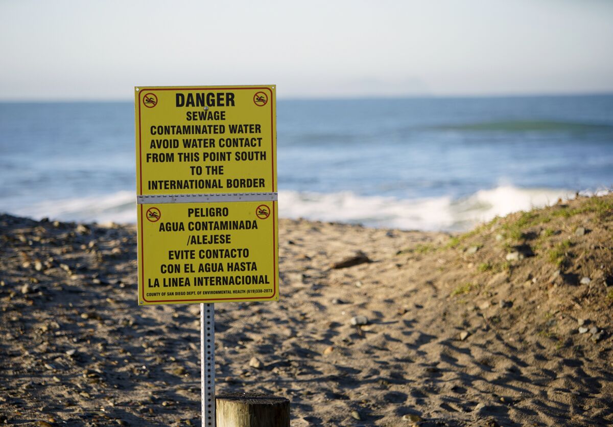 Contaminated water signs posted along the southern part of the beach, as Imperial Beach prepares for the King Tide along the San Diego coastline, Jan. 10, 2019. The U.S. Environmental Protection Agency has announced a $630 million plan to capture and treat sewage-tainted water that routinely flows over the border from Tijuana into San Diego Bay. (Alejandro Tamayo/The San Diego Union-Tribune via AP)