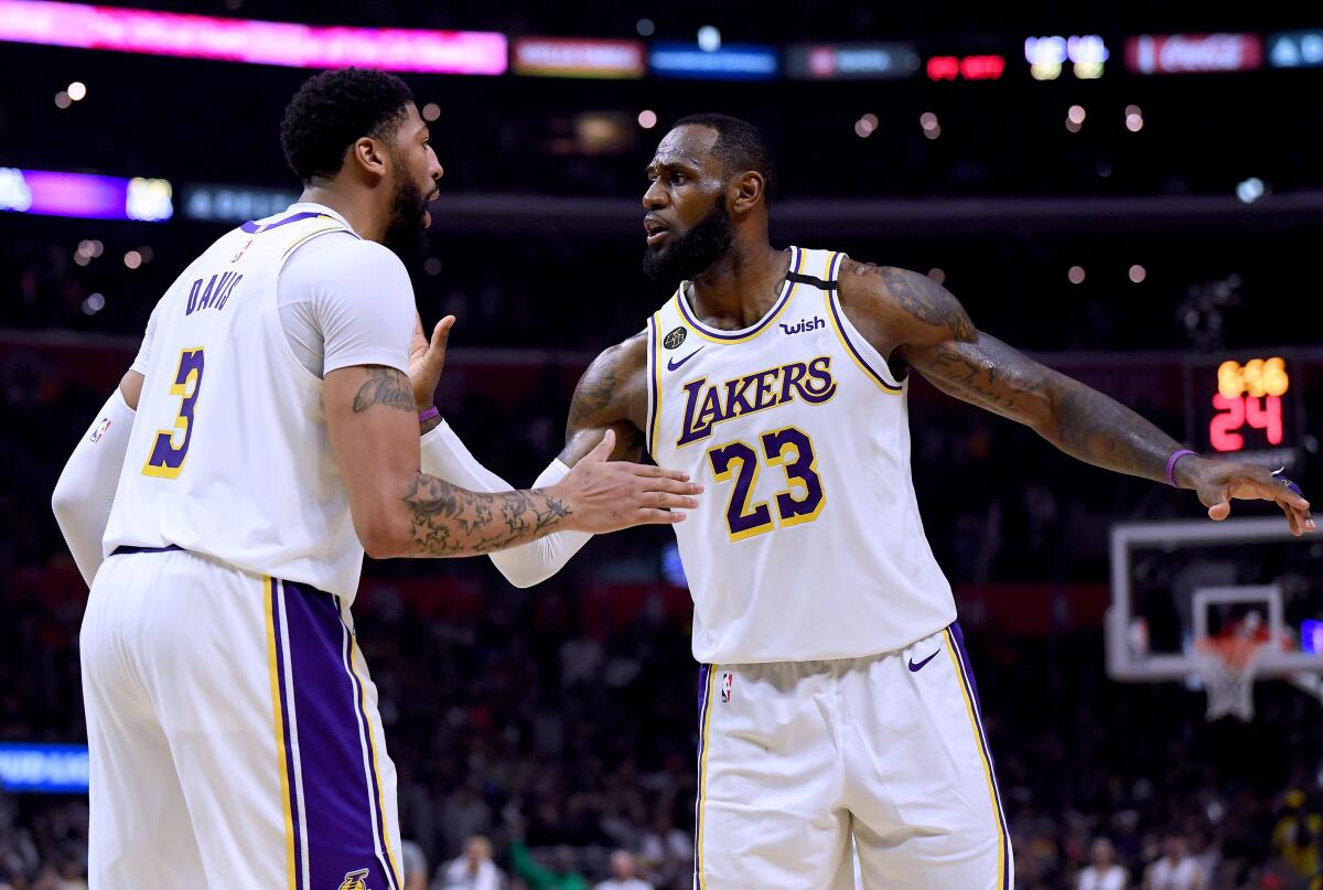 Lakers forwards Anthony Davis (3) and LeBron James (23) celebrate during a 112-103 win over the Clippers on March 8, 2020.