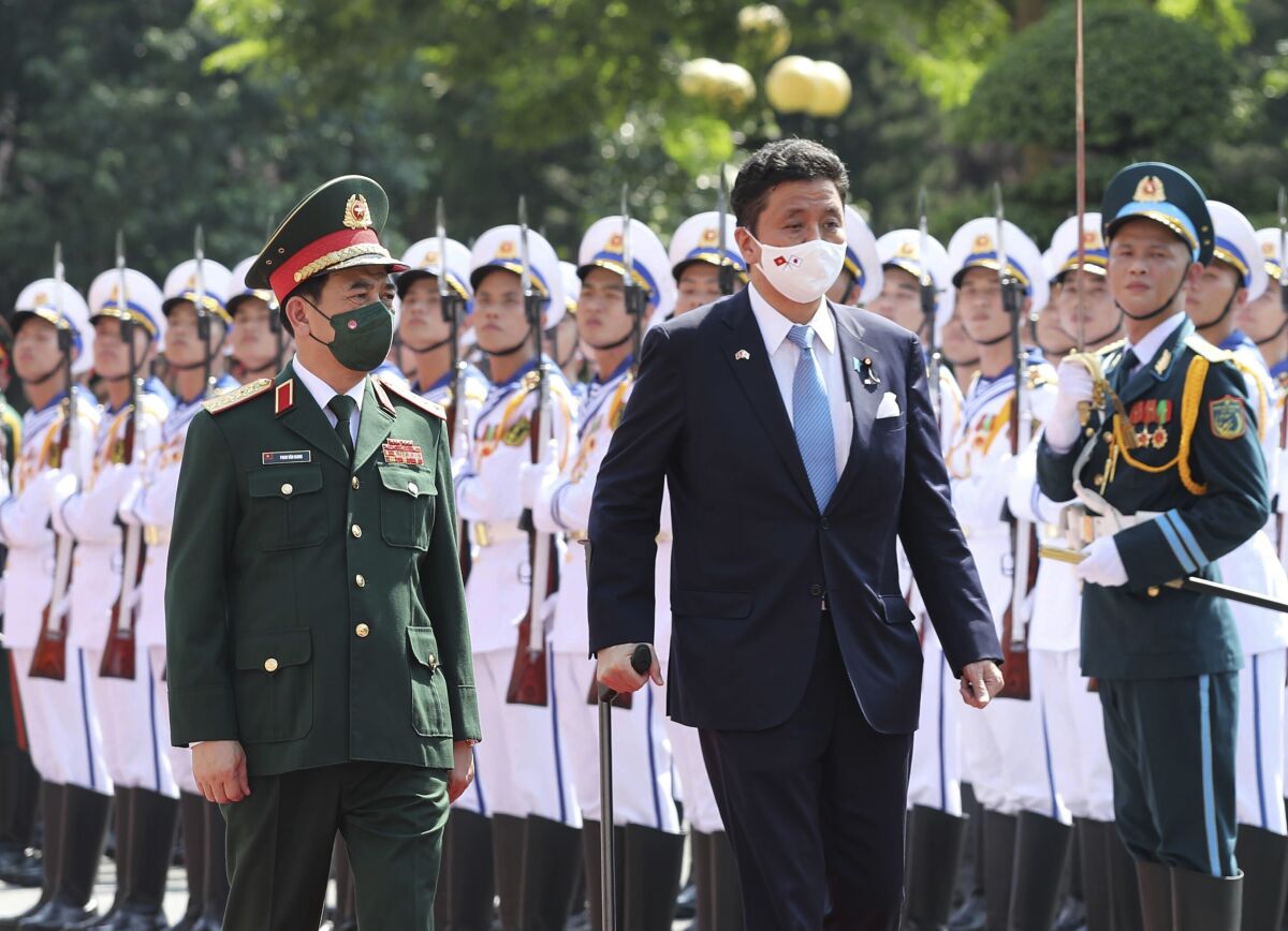 Vietnamese Defense Minister Phan Van Giang, left, and Japanese Defense Minister Nobuo Kishi review honor guards in Hanoi, Vietnam Sunday, Sept. 12, 2021. Japan can now give defense equipment and technology to Vietnam under an agreement signed Saturday, as the two countries step up their military cooperation amid worries about China's growing military influence. (Nguyen Trong Duc/ VNA via AP)