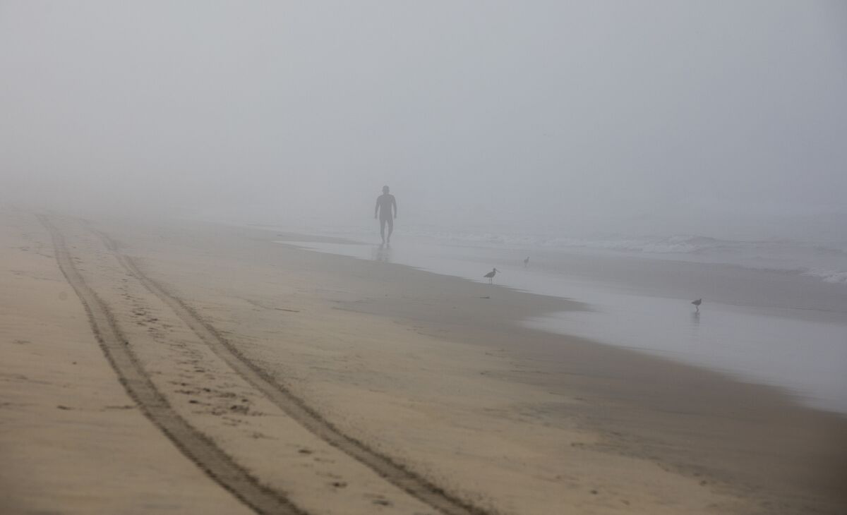 A migrant walks along the beach in Borderfield State Park after swimming across from Tijuana.