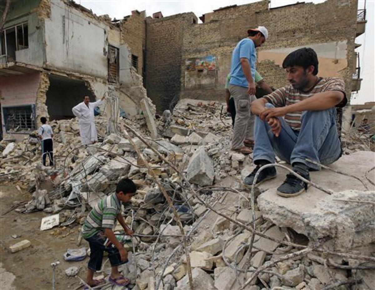 Iraqis inspect the scene of a bomb attack in Baghdad, Iraq, Wednesday, April 7, 2010. At least seven bombs ripped through apartment buildings across Baghdad on Tuesday and another struck a market, killing 54 people and wounding 187.(AP Photo/Hadi Mizban)