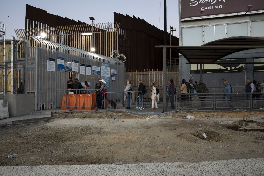 Tijuana, Baja California - November 18: People wait in line to enter the United States outside of the San Ysidro Port of Entry, which is being expanded and will open in the coming months, on Friday, Nov. 18, 2022 in Tijuana, Baja California. (Ana Ramirez / The San Diego Union-Tribune)