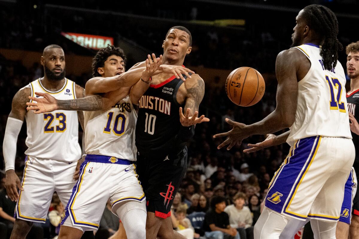 Lakers guard Max Christie ties up Rockets forward Jabari Smith Jr., allowing Lakers forward Taurean Prince to grab a rebound.