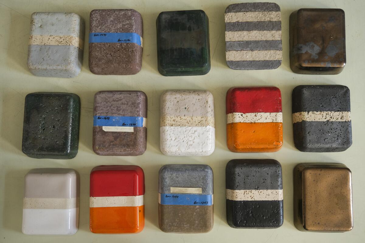 Glazed clay rectangles in three rows of five each, in different colors