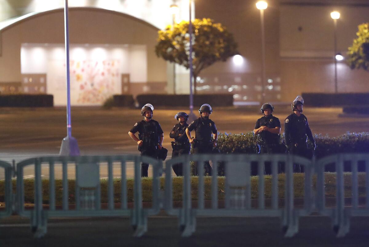 Police stand on the corner of South Coast Plaza at Sunflower Avenue and Bristol Street in Costa Mesa on Monday, guarding against a demonstration over the death of George Floyd.