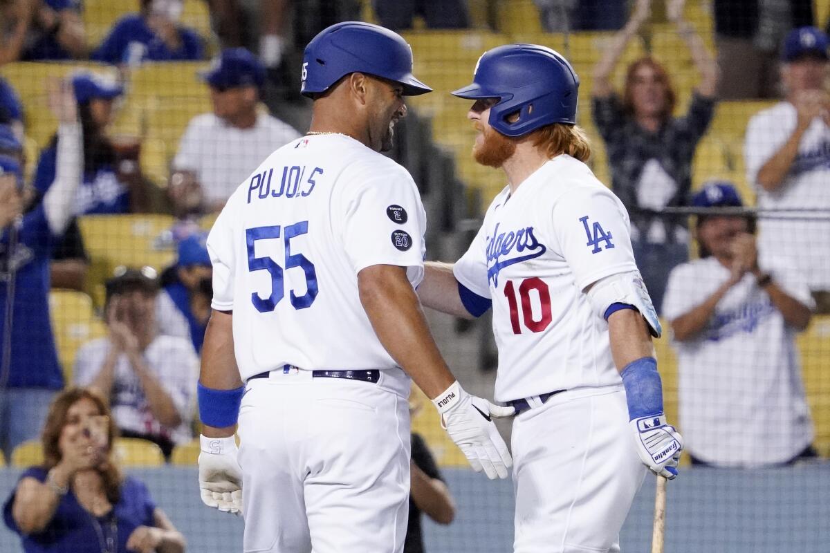 Albert Pujols is congratulated by Dodgers teammate Justin Turner after hitting a solo home run.