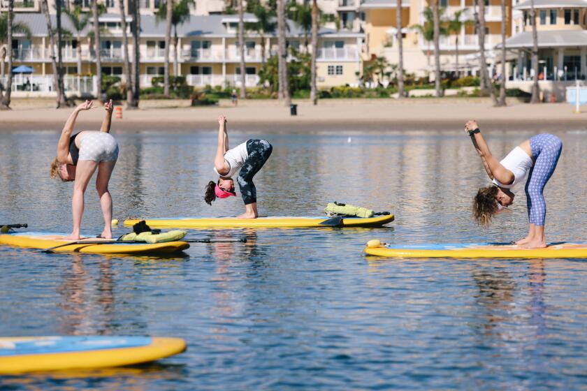 Marina Del Rey, CA - October 29: A group of women take a yoga class on the water with "YOGAqua" at Marina "Mother's" Beach on Sunday, Oct. 29, 2023 in Marina Del Rey, CA. (Dania Maxwell / Los Angeles Times)