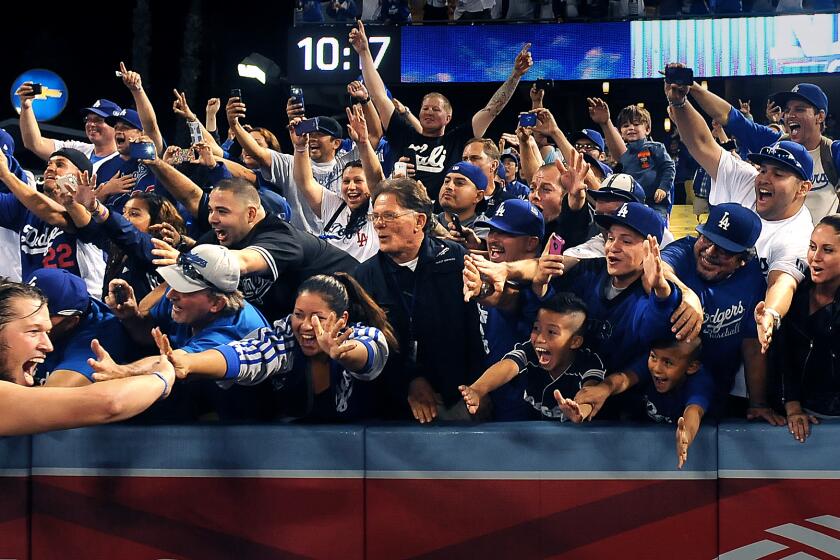 Dodgers' Clayton Kershaw celebrates with fans after defeating the Braves in game 4 of the National League Division Series.