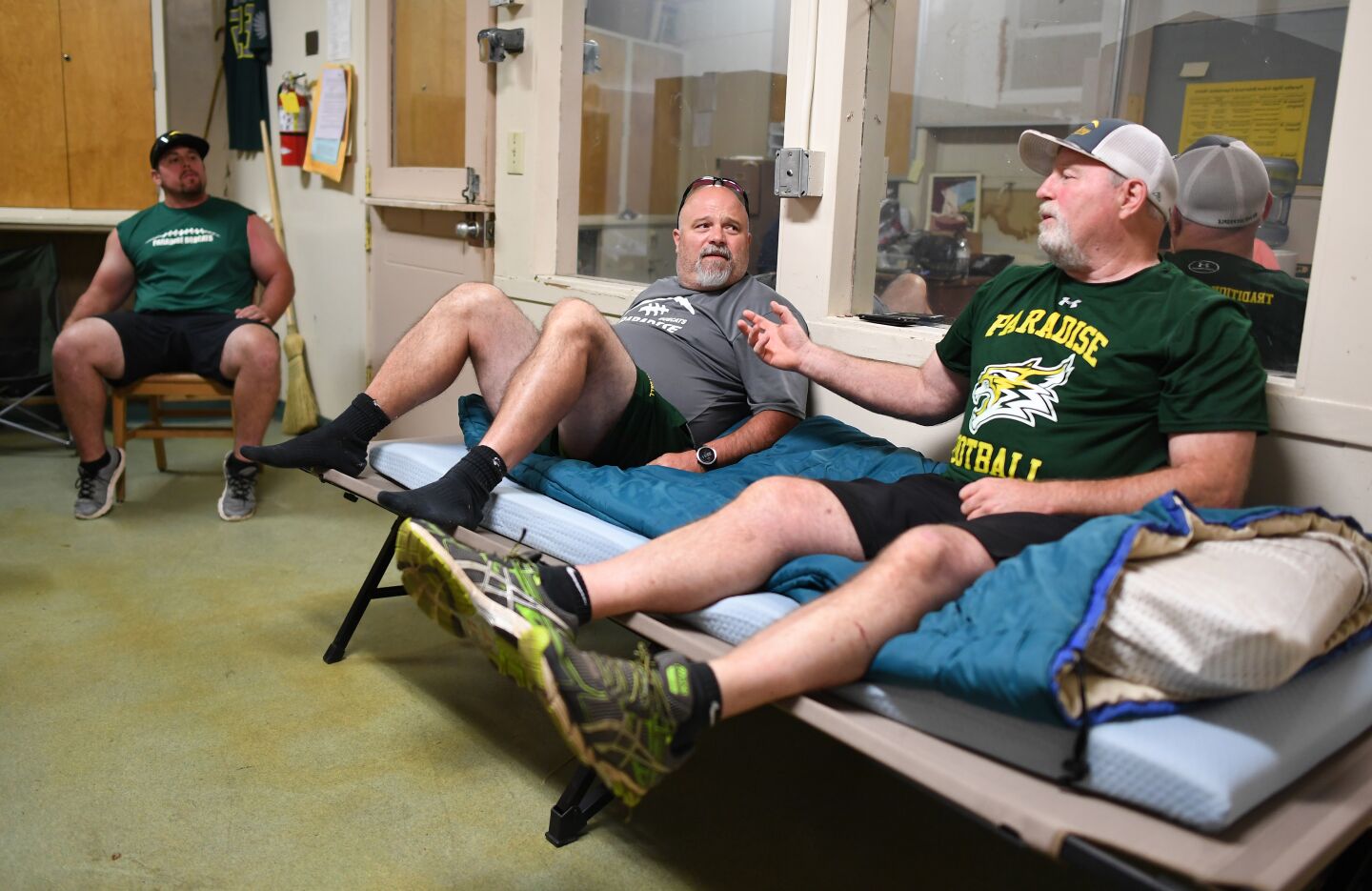 Paradise coach coach Rick Prinz, right, speaks with assistants Bobby Richards, left, and Nino Pinocchio in his office.