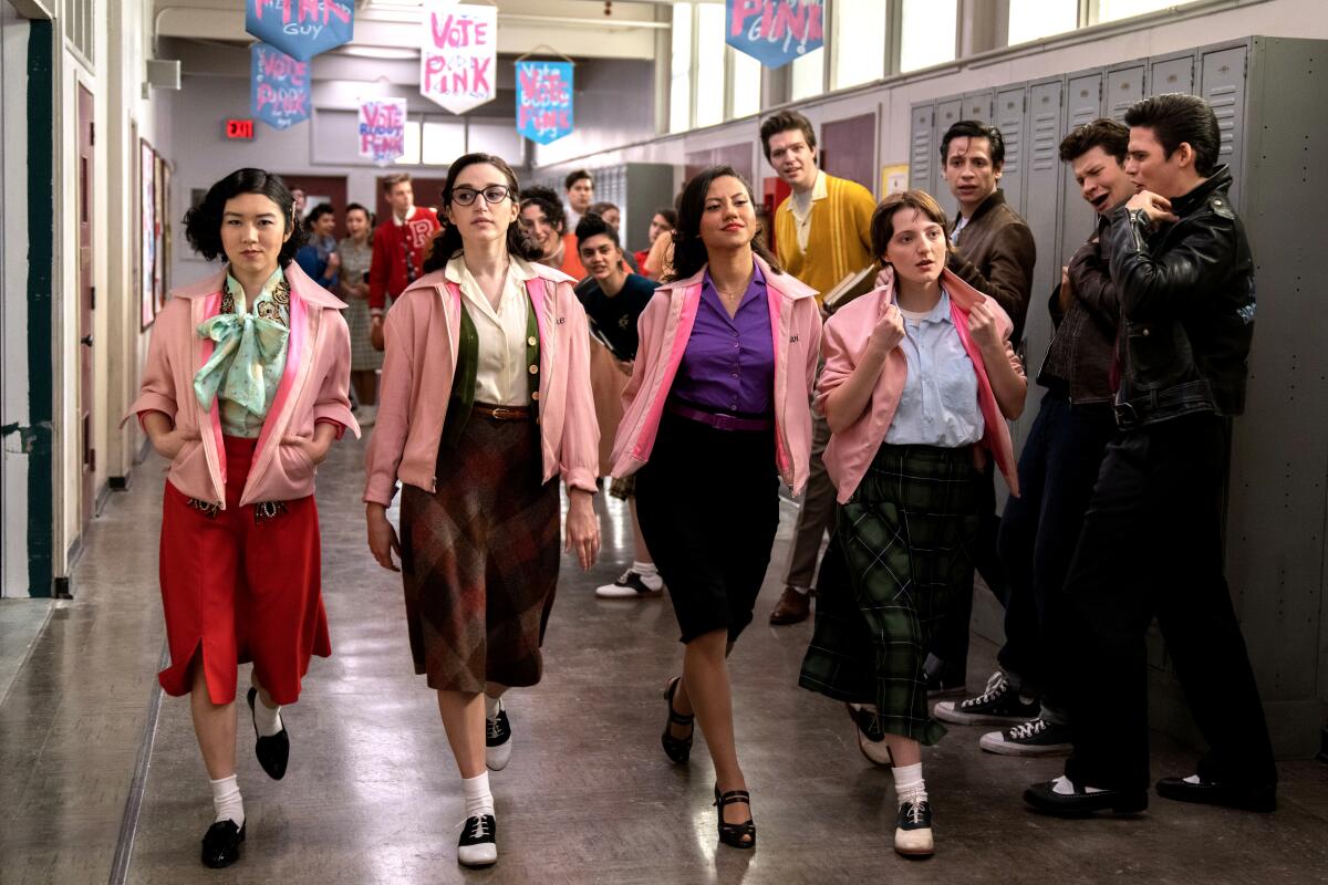 Young women in 1950's-style outfits stroll a school hallway in "Grease: Rise of the Pink Ladies."