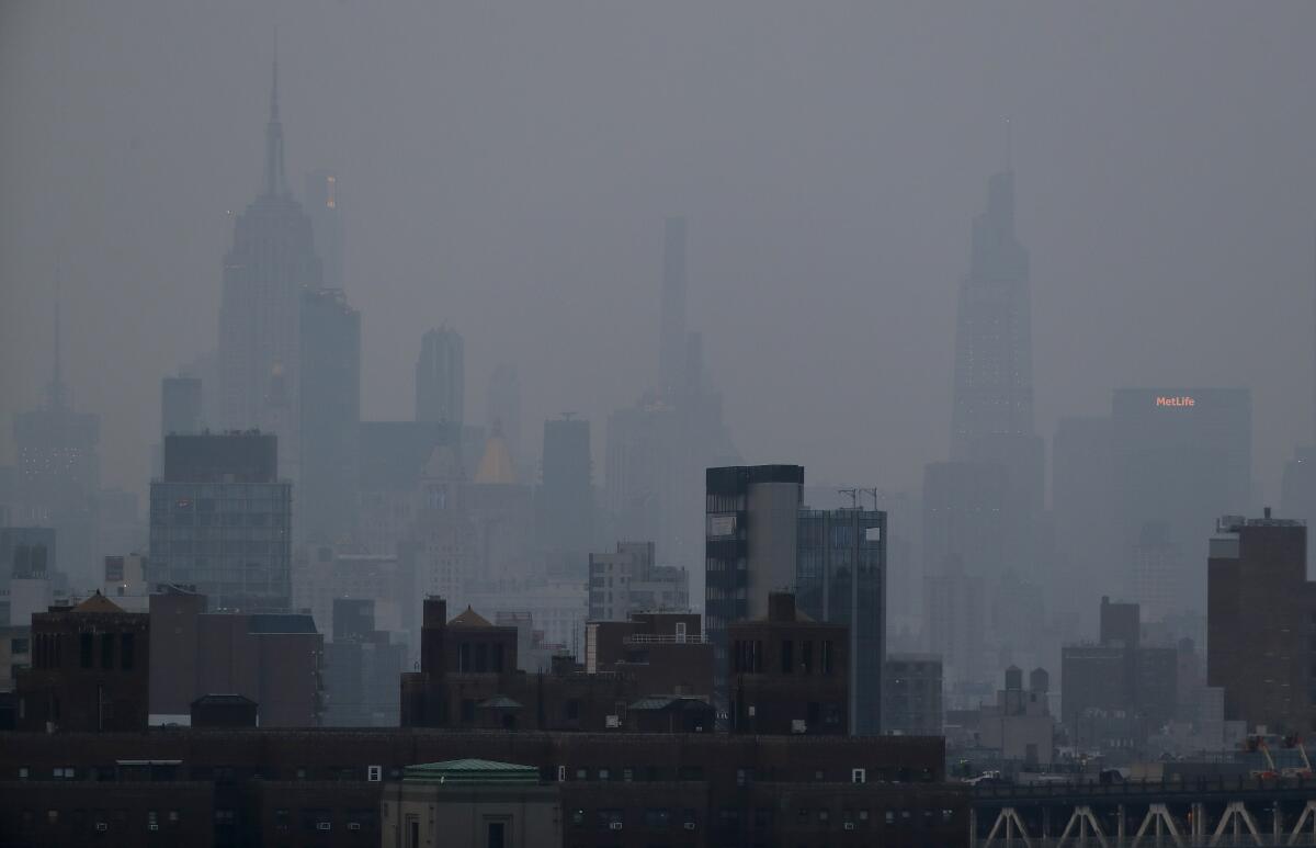 A thick haze hangs over Manhattan on July 20, attributed to smoke from fires in Canada and the Pacific Northwest.