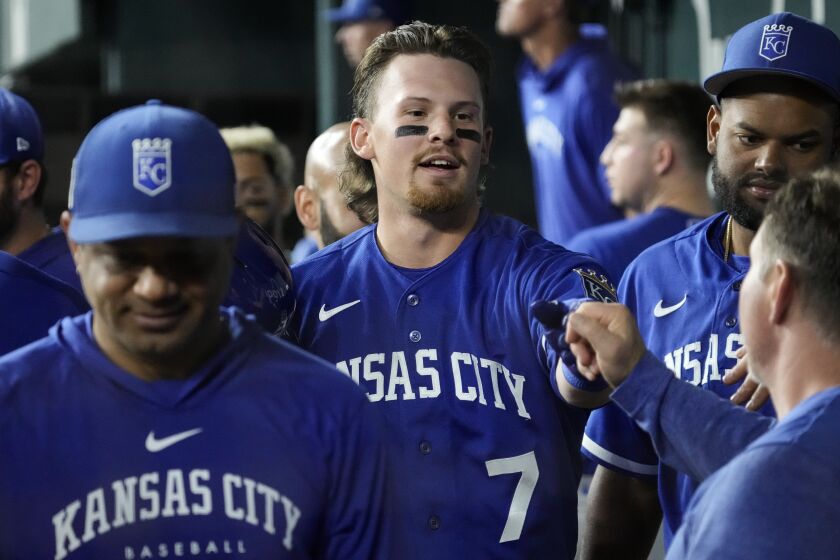 Kansas City Royals Bobby Witt Jr. (7) is congratulated by teammates after hitting a sacrifice fly during the third inning of a spring training baseball game against the Texas Rangers on Monday, March 27, 2023, in Arlington, Texas. (AP Photo/Sam Hodde)