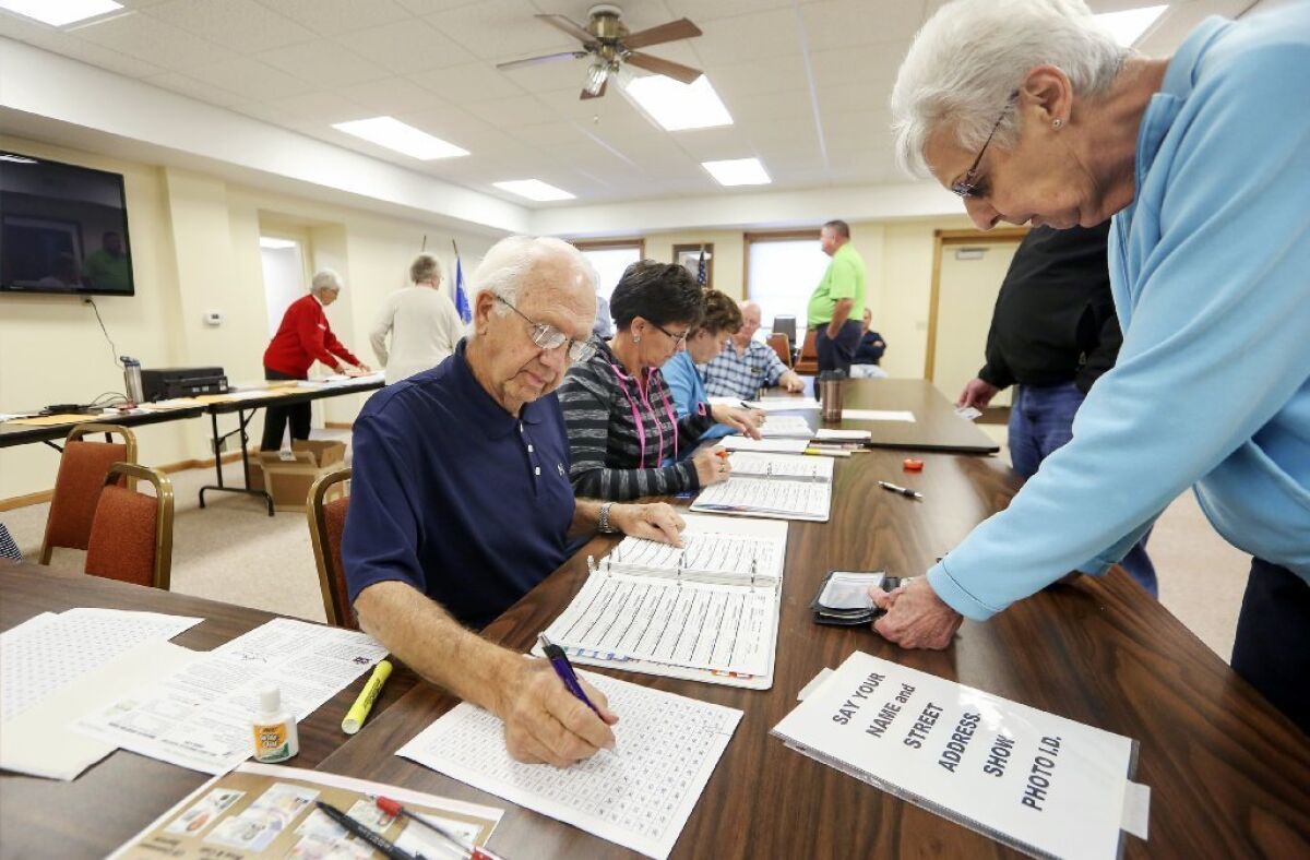 John Richard, left, checks in voters on election day at Jamestown Town Hall in Kieler, Wis., on Tuesday, Nov. 8.