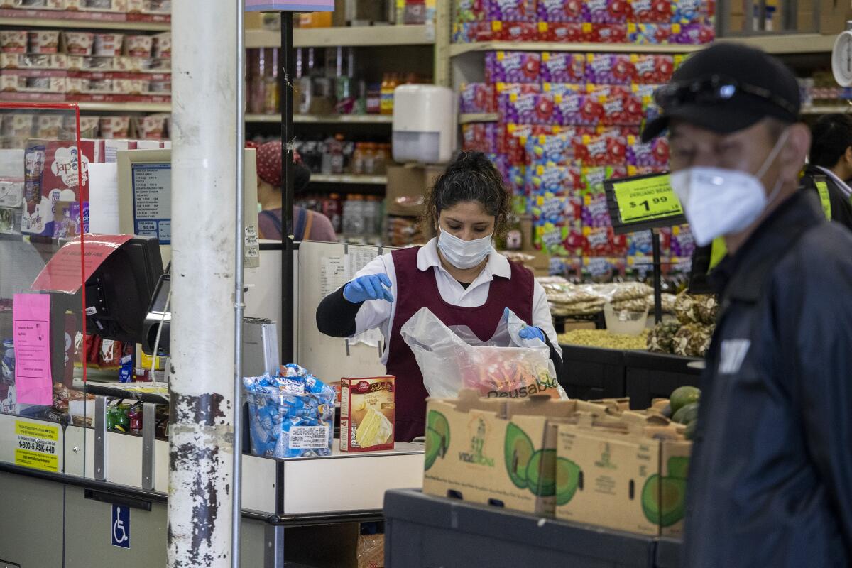 Supermarket cashier wears a masks