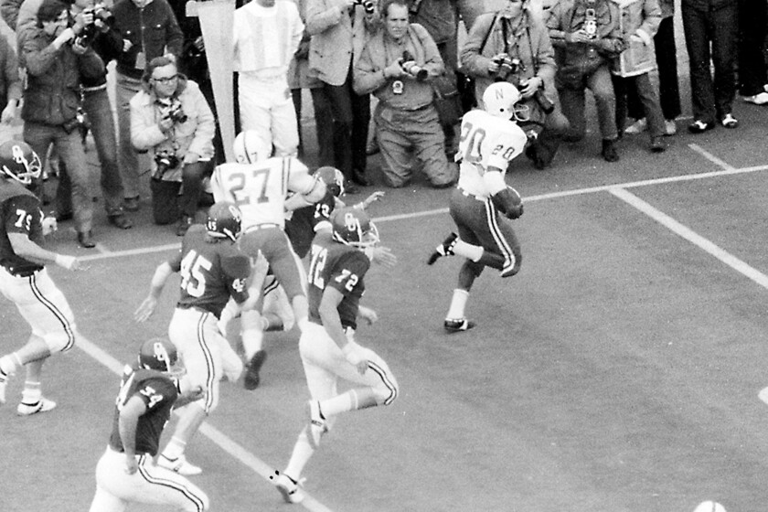 FILE - In this Nov. 25, 1971, fie photo, Nebraska's Joe Blahak (27) delivers the final block to spring Johnny Rodgers (20) for a touchdown on a punt return in the first quarter of an NCAA college football game in Norman, Okla. Reports that Nebraska wants to back out of playing at Oklahoma this season didn't sit well with one of the stars of the 1971 Game of the Century. The game scheduled Sept. 18 in Norman, Oklahoma, would mark the 50th anniversary of Nebraska's 35-31 win over the Sooners in a clash of the Nos. 1 and 2 teams in the nation. (Bob Gorham/Lincoln Journal Star via AP, File)