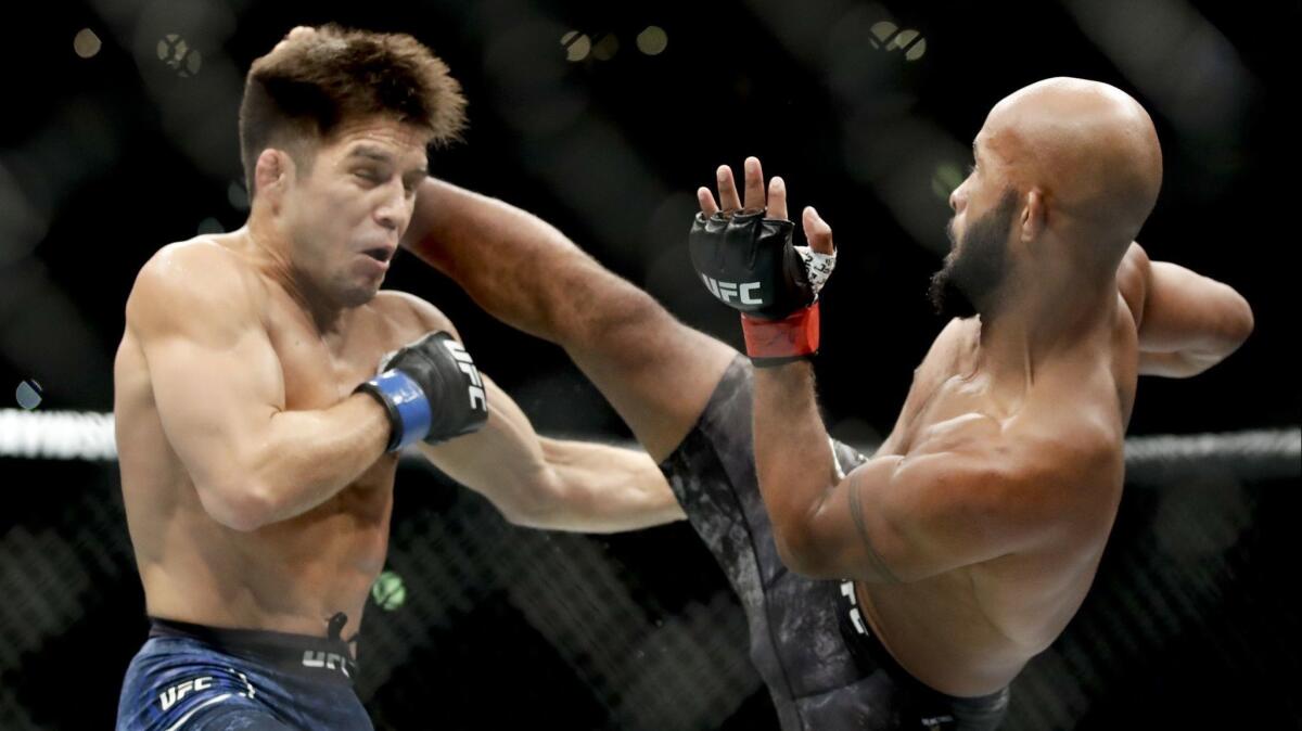 Demetrious Johnson kicks Henry Cejudo during their UFC flyweight title mixed martial arts bout at UFC 227 on Saturday.