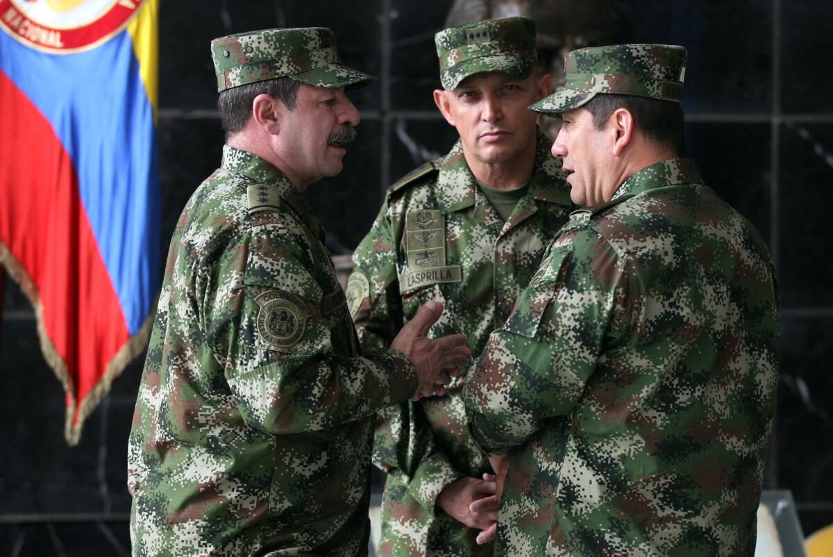 En esta magen de archivo del 18 de febrero de 20145, el nuevo comandante de las fuerzas armadas de Colombia, el general Juan Pablo Rodríguez, a la derecha, habla con el recíén nombrado jefe del estado mayor, el general Javier Florez, a la izquierda, y el comandante y general Jaime Lasprilla, en el centro, tras una rueda de prensa donde el ministro de Defensa, Juan Carlos Pinzon anunció la destitución del ex responsable de las fuerzas armadas, el general Leonardo Barrero, en Bogotá, Colombia. Los generales Rodríguez y Lasprilla están entre las decenas de altos mandos del ejército colombiano implicados en la matanza de 3.000 civiles considerados falsamente guerrilleros dijo Human Rights Watch.