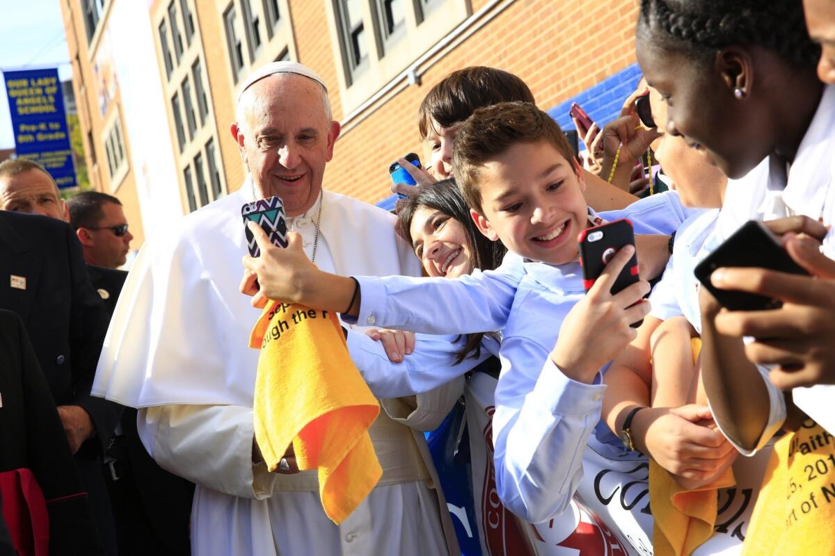Students snap selfies of Pope Francis when the pontiff visited Our Lady Queen of Angels School in East Harlem, N.Y., last Friday.