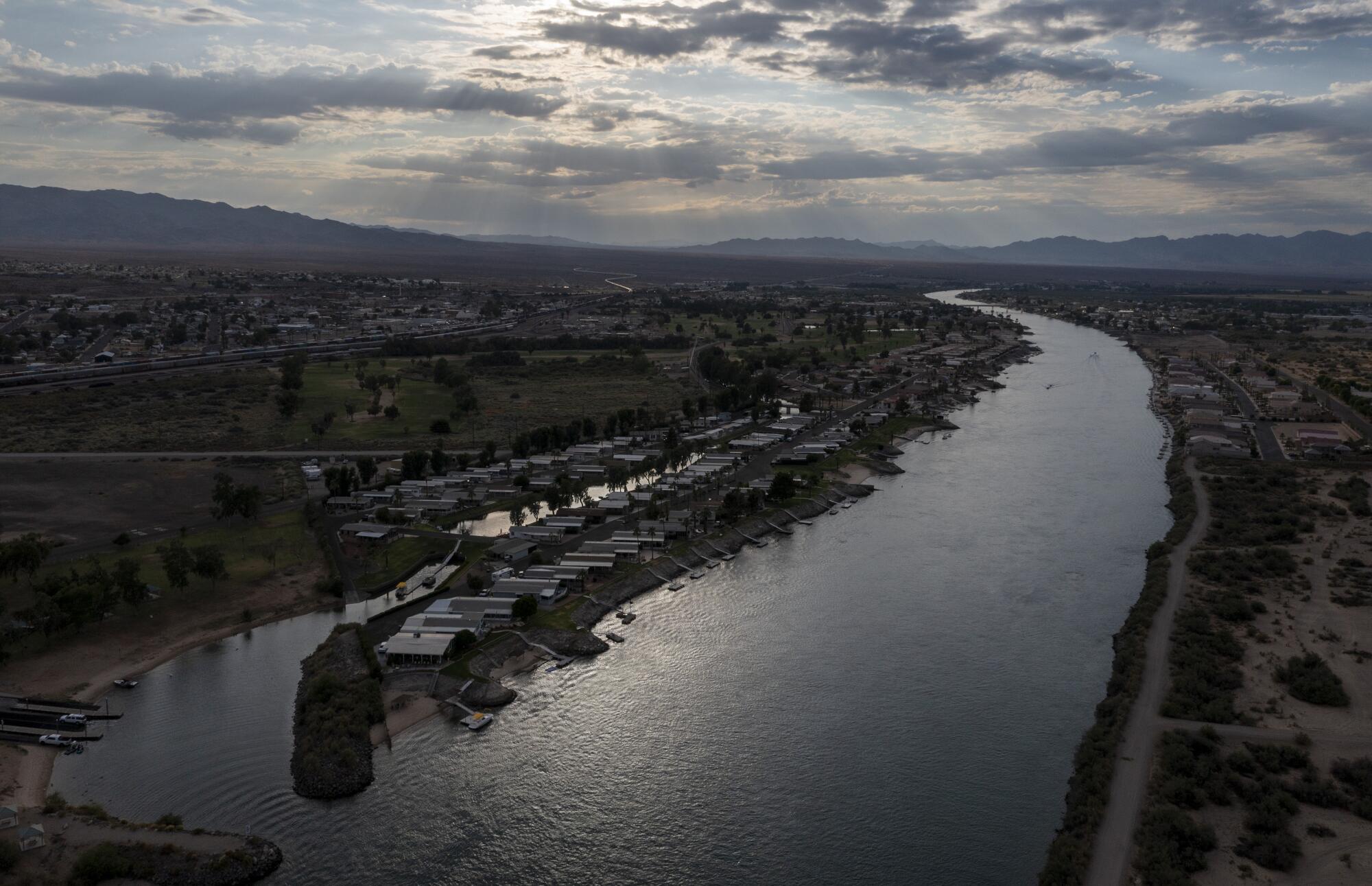 El río Colorado fluye a lo largo de la ciudad de Needles, en el desierto de Mojave, a la izquierda.