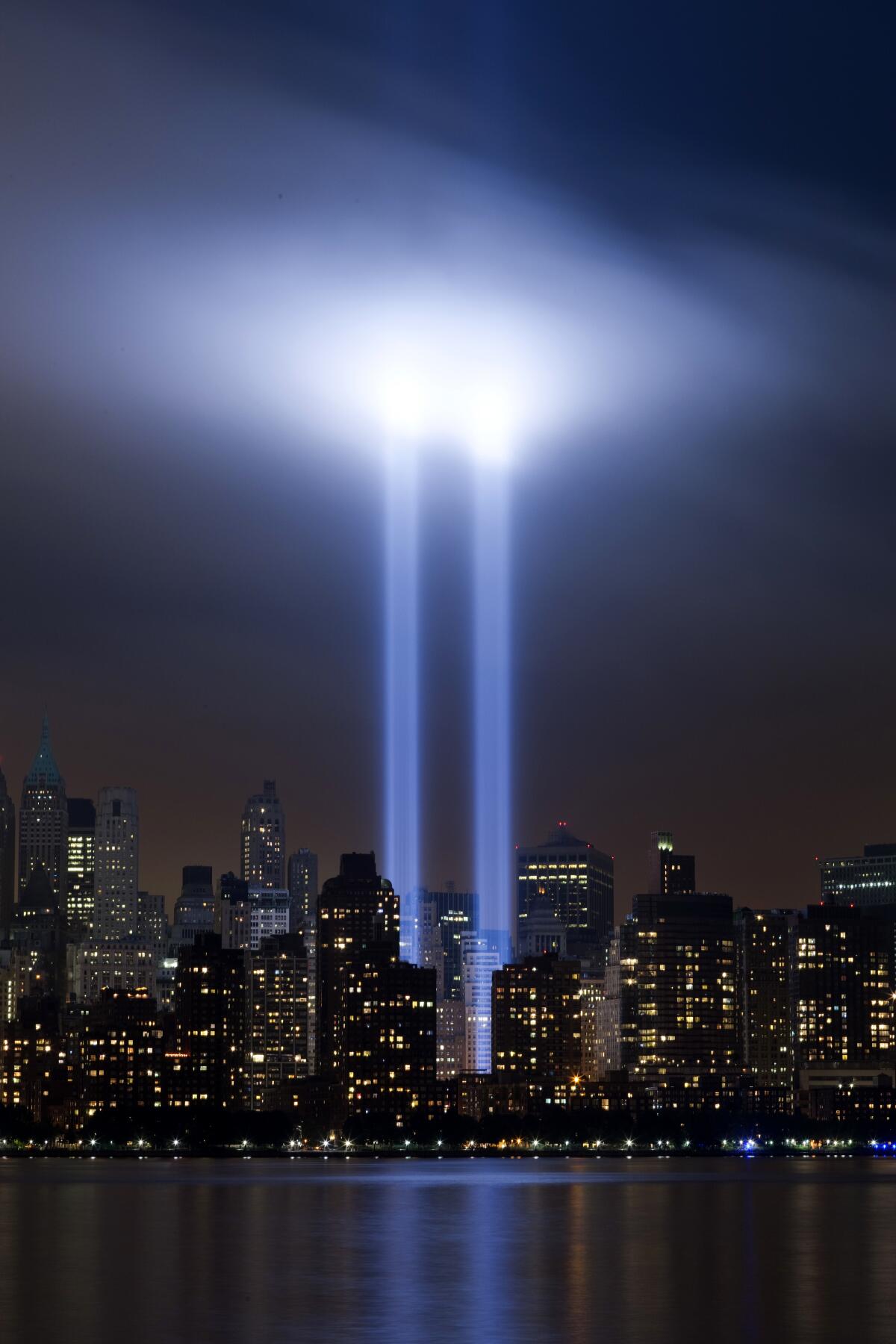 Twin beams of blue light shine up into the sky above Lower Manhattan.