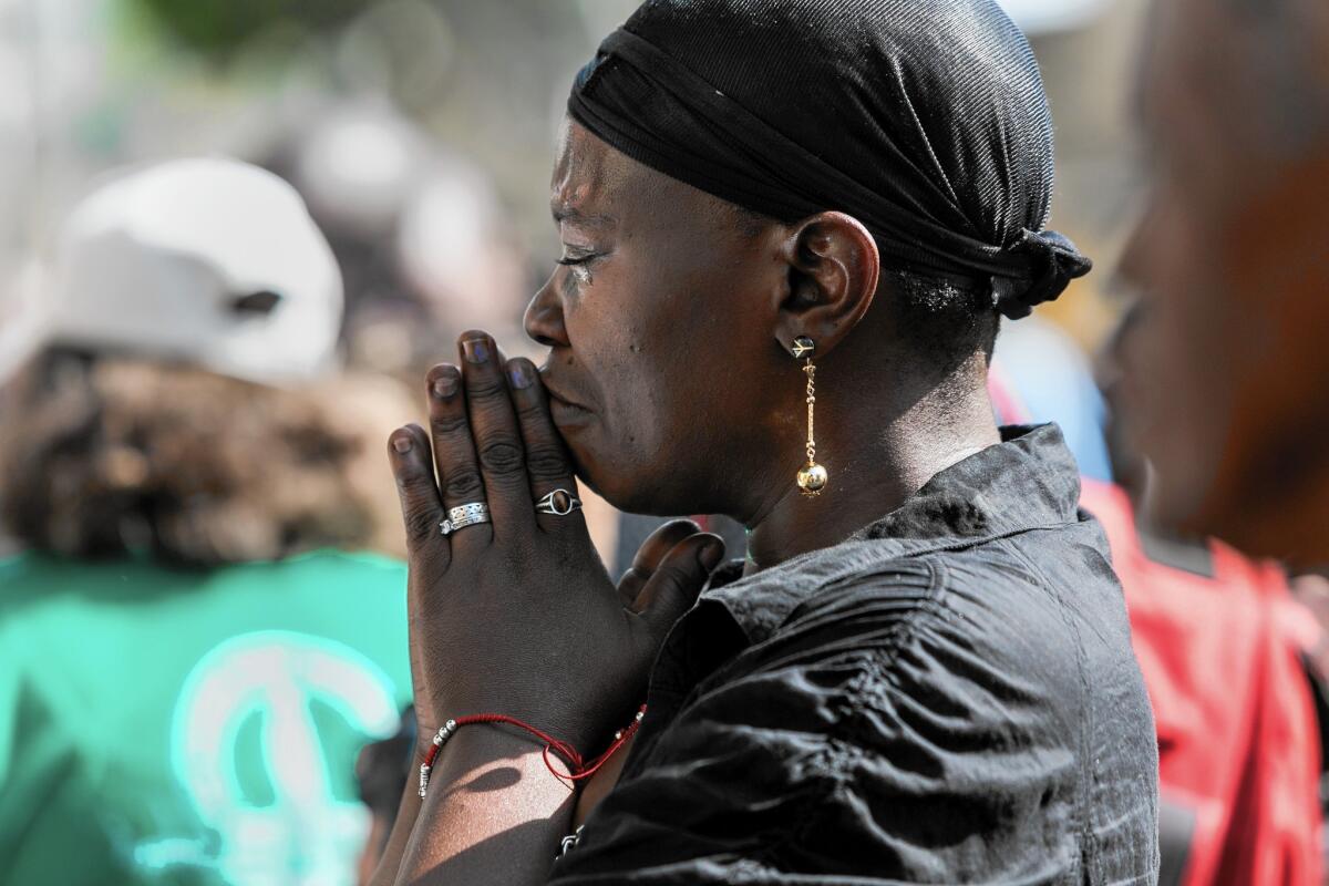 A woman weeps during a public memorial for Charley Leundeu Keunang, a homeless man shot and killed during a struggle with the LAPD on skid row.