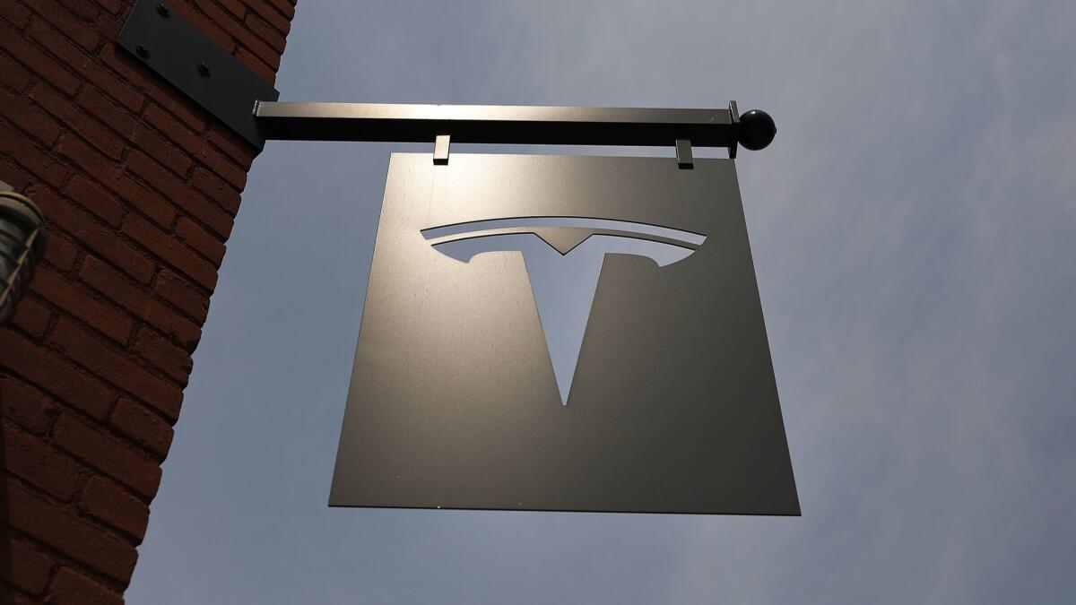 The Tesla logo hangs outside a showroom in New York City, where Chief Executive Elon Musk faces charges of investor fraud.