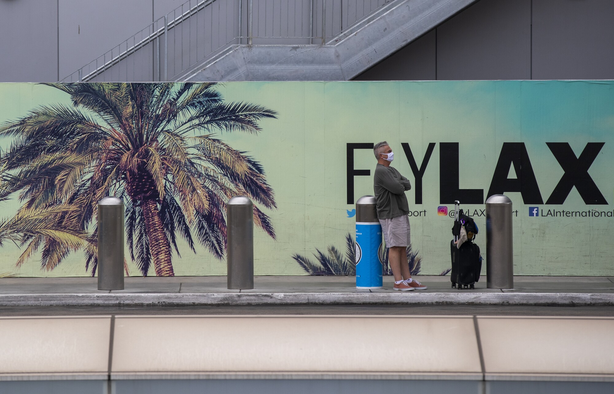 A traveler waits for a ride after arriving at Los Angeles International Airport.