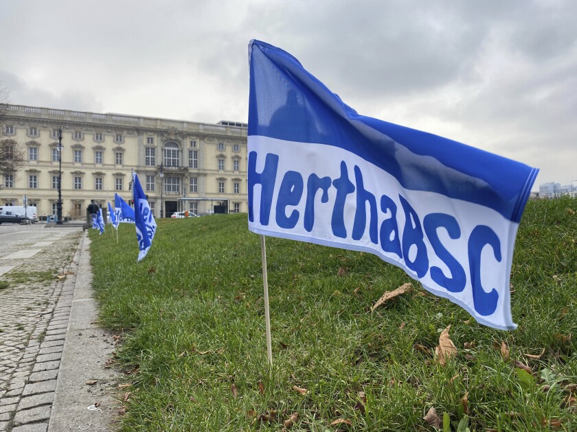 Flags from Hertha BSC are in front of the Humboldt Forum in Berlin, Germany, Tuesday, Dec.1,2020. Before the third Bundesliga duel against city rivals 1 FC Union on Friday in the Olympic Stadium, blue and white Hertha flags were placed in several places in Berlin during the night in a fan action. (Paul Zinken/dpa via AP)