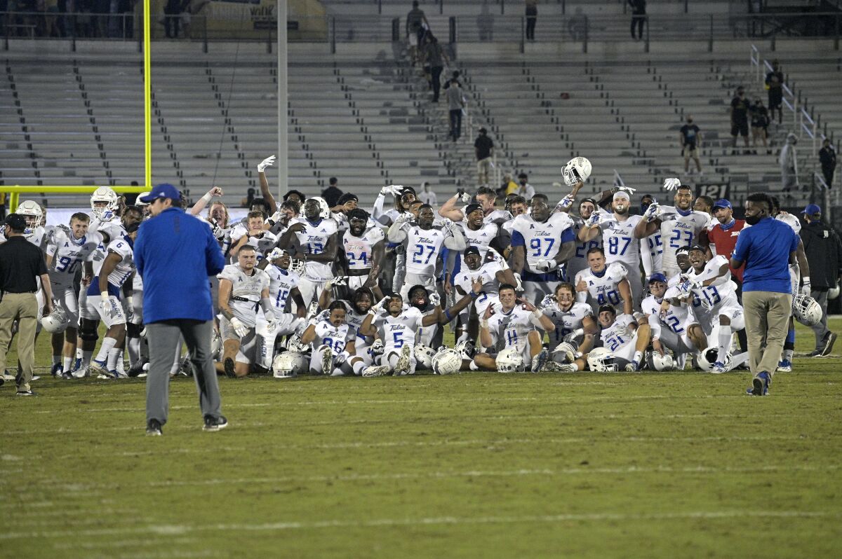 Tulsa players pose on the middle of the field after a win over Central Florida during an NCAA college football game Saturday, Oct. 3, 2020, in Orlando, Fla. Tulsa's win snapped UCF's 21-game home winning streak. (AP Photo/Phelan M. Ebenhack)