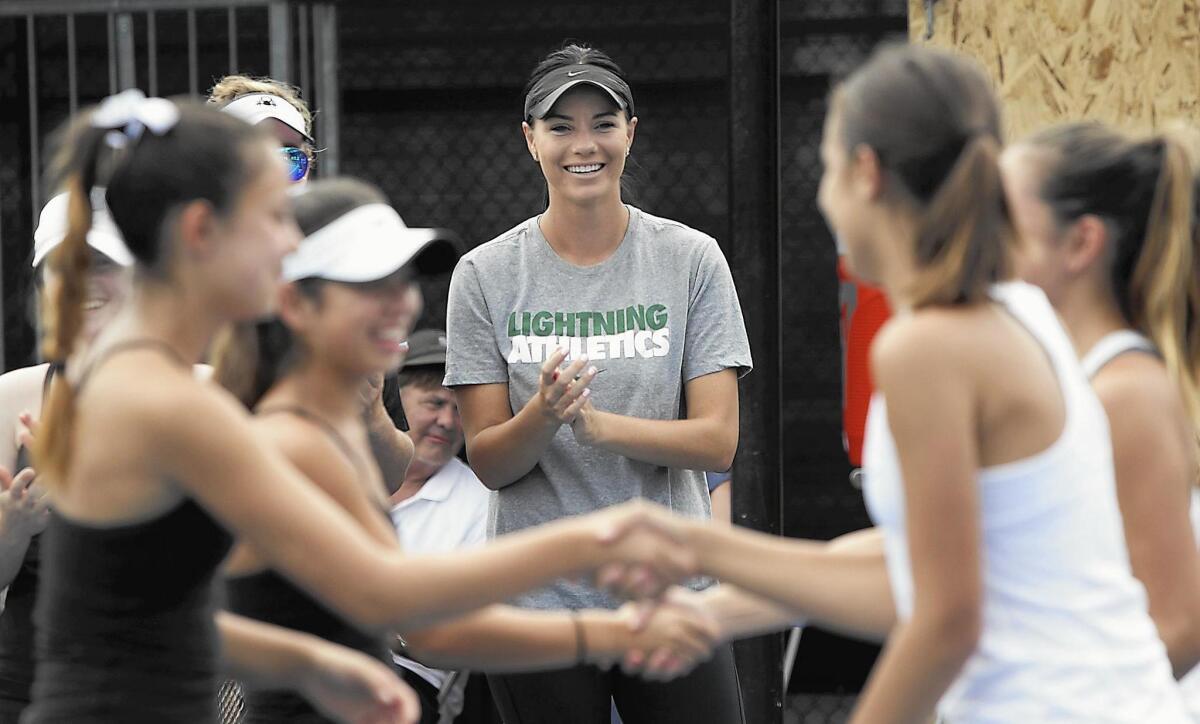 New Sage Hill girls’ tennis coach Cierra Gaytan greets players during recent match against Laguna Beach.