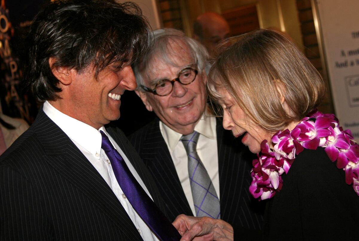 Griffin Dunne, Dominick Dunne -- both in suits and ties -- and Joan Didion, with a lei around her neck.