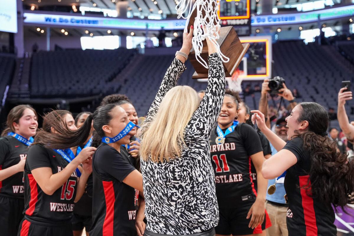 Harvard-Westlake coach Melissa Hearlihy hoists the Division II state championship trophy for her players.