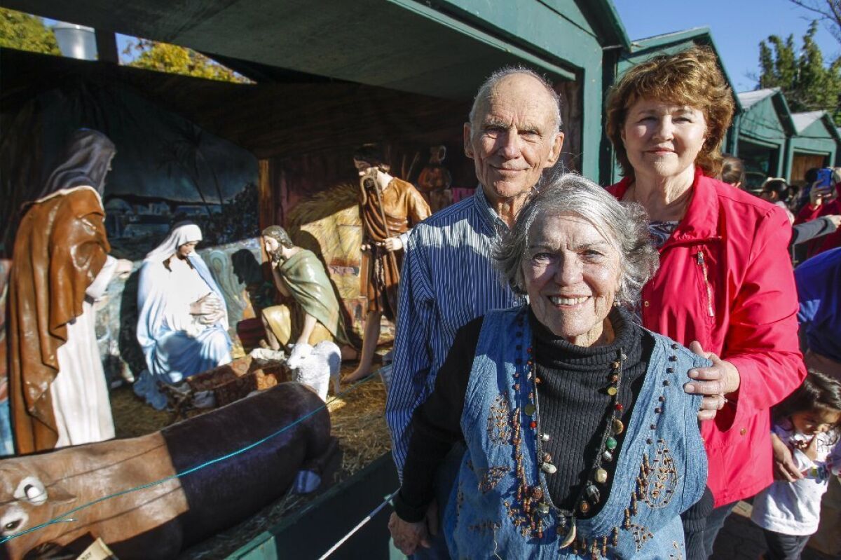 Artist Barbara Jacobson, right, and Betty and Woody Whitlock, who worked together to restore the figurines for the Community Christmas Center's Nativity display for December Nights at Balboa Park in San Diego on Saturday.