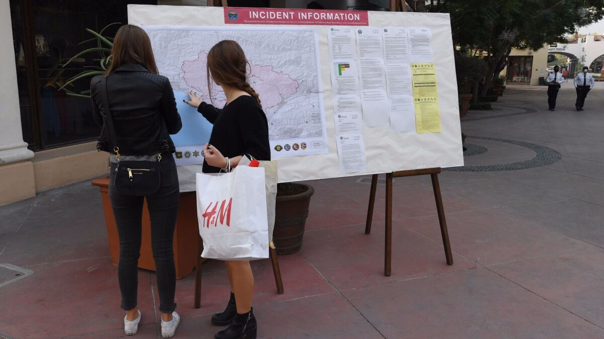 Shoppers on Santa Barbara's main drag, State Street, check a fire incident map Tuesday.
