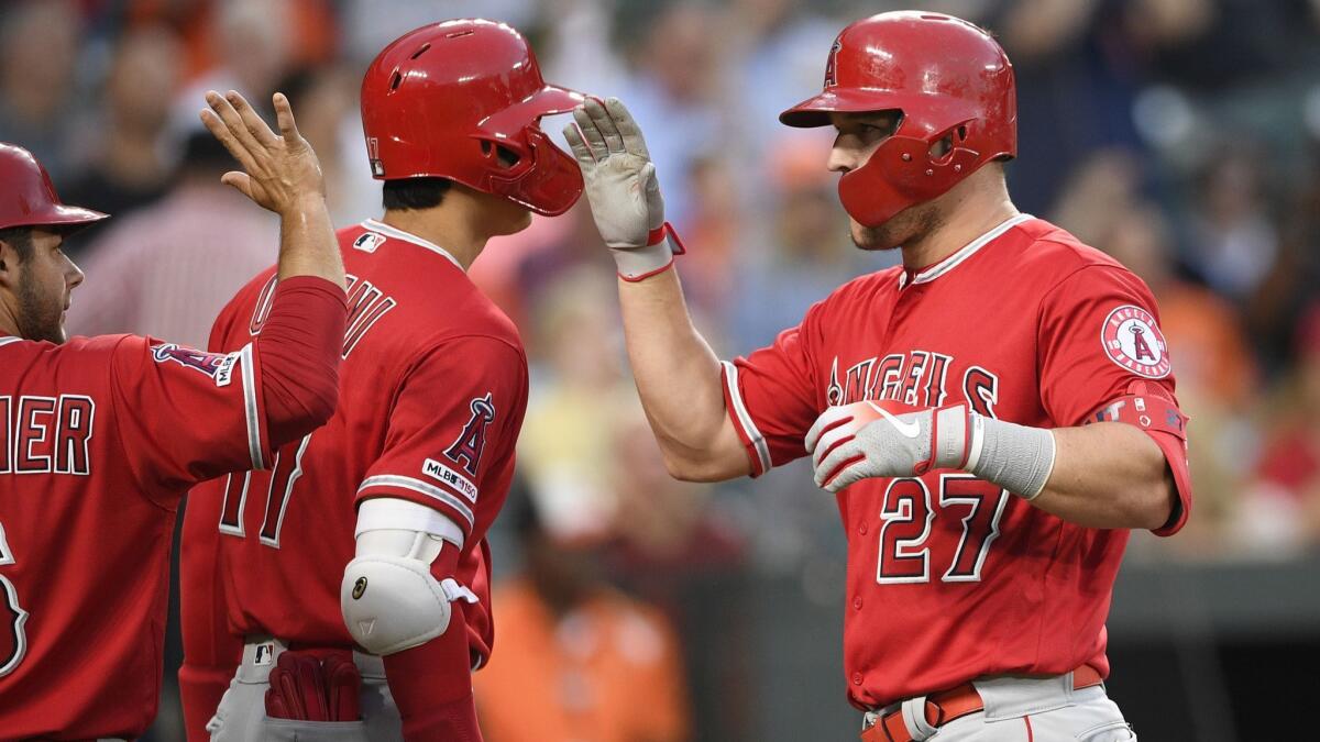 Angels' Mike Trout (27) celebrates his two-run home run with Shohei Ohtani, center, and David Fletcher during the third inning against the Baltimore Orioles on Friday in Baltimore.