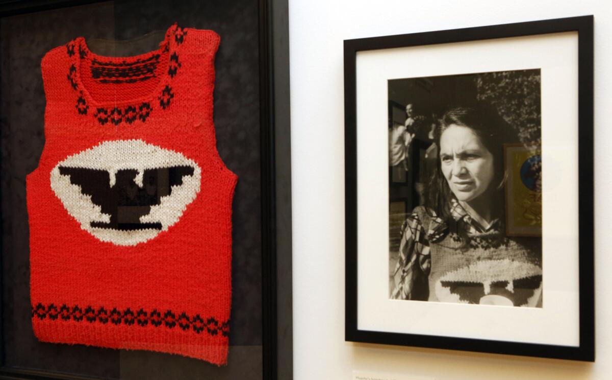 Dolores Huerta, cofundadora de la Unión de Campesinos (UFW por sus siglas en inglés) con un chaleco tejido con el logotipo de la unión en una fotografía de 1979 de Rudy Rodríguez presentada junto al chaleco en la exposición "Viva la Causa! Dolores Huerta and the Struggle for Justice" en el Museo de la Plaza de la Cultura y Artes en Los Angeles. "One Life: Dolores Huerta", una exposición sobre la vida de la activista latina será presentada en la Galería Nacional de Retratos en Washington D.C. del 3 de julio de 2015 al 15 de mayo de 2016. (Foto AP/Damian Dovarganes)