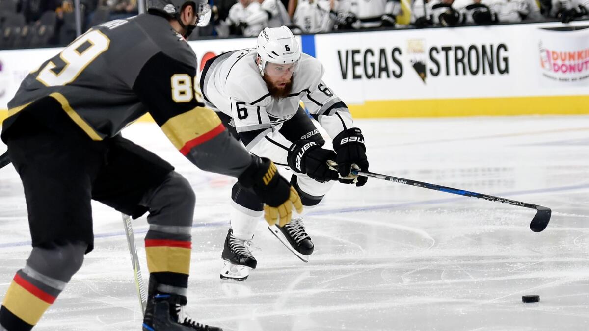 Kings defenseman Jake Muzzin reaches for the puck in front of Vegas right wing Alex Tuch on Feb. 27.